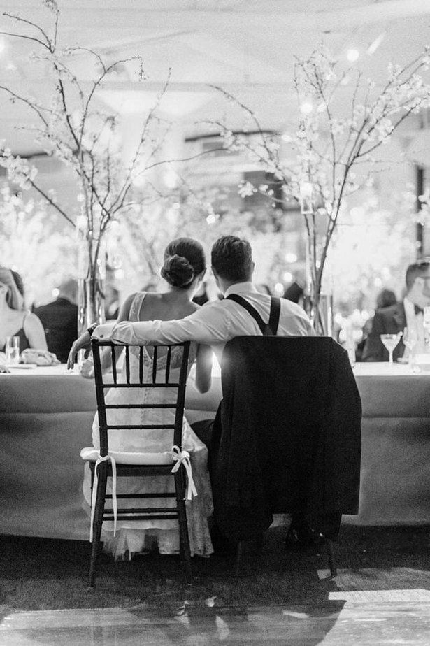 bride and groom sitting at their wedding table looking at their guests at tribeca rooftop