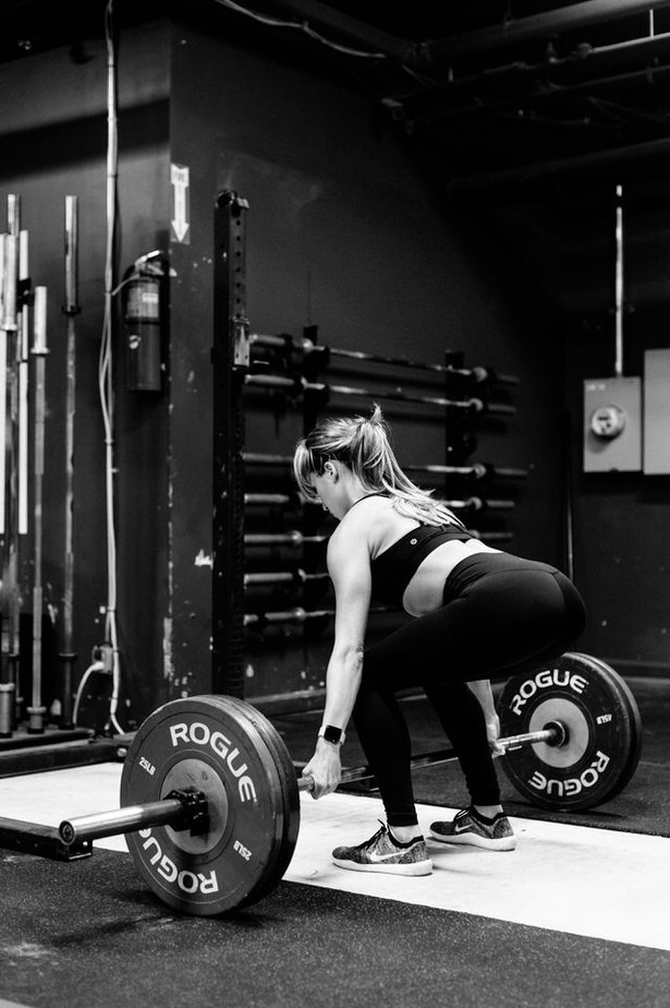 female working out with barbell in a gym