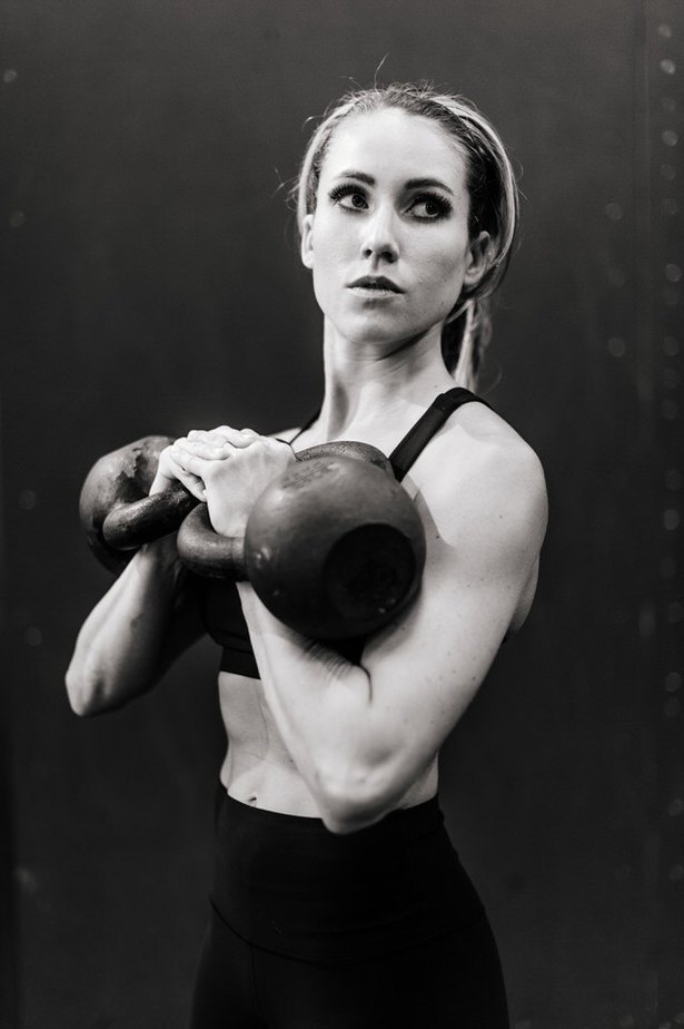 female working out with kettlebells in a gym